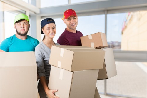 Professional movers loading items into a van on a Barnes street