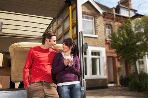 Removal workers moving household furniture through a Barnes property